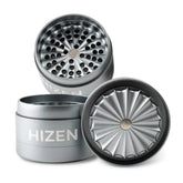 Hizen Grinder zahnlos 63mm in Grau – geöffneter 4-teiliger Aluminium-Grinder mit sternförmigem Mahlwerk, Lochsieb und Magnetverschluss, drei Teile auseinander dargestellt